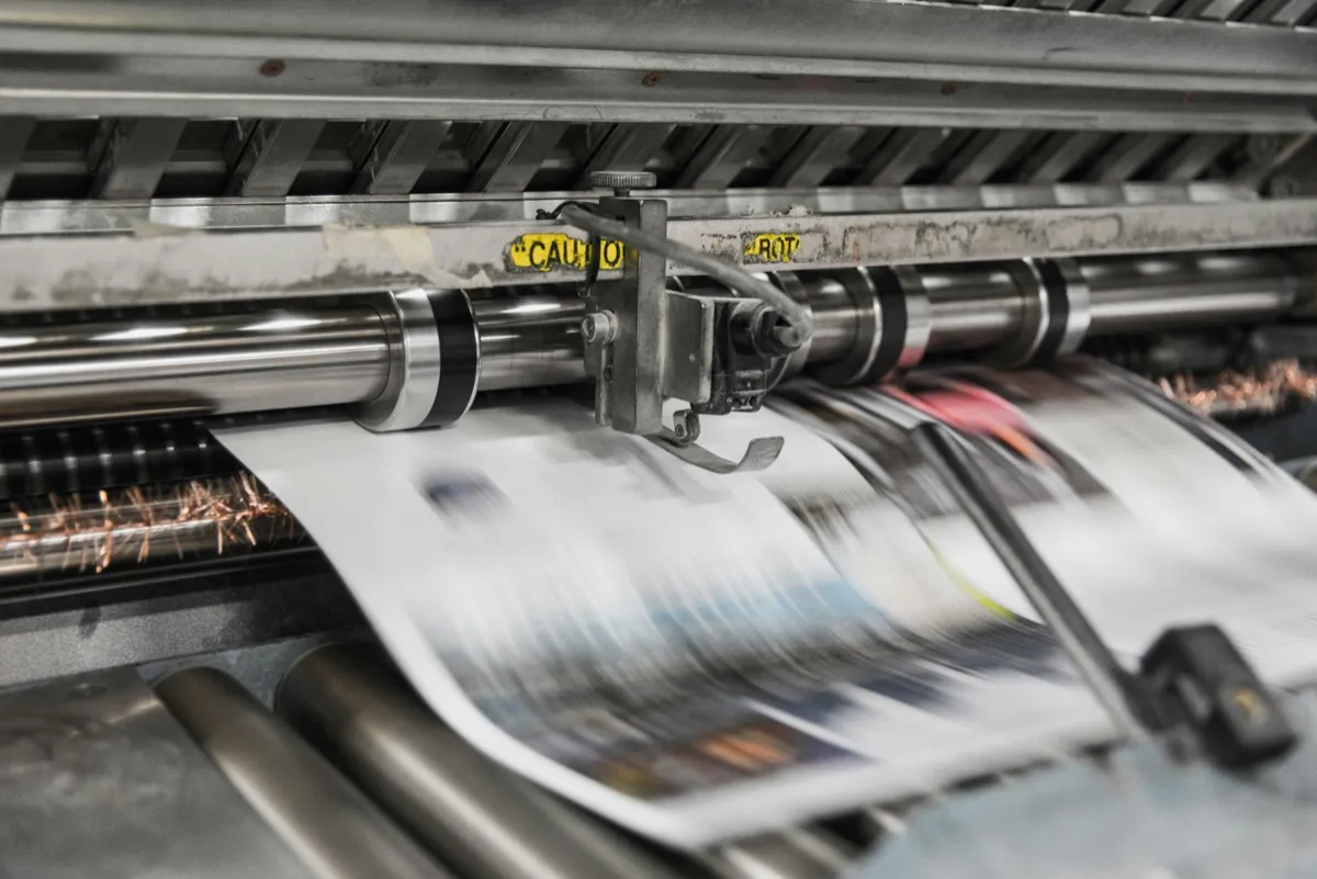 Presse offset industrielle en action, feuilles imprimées en mouvement