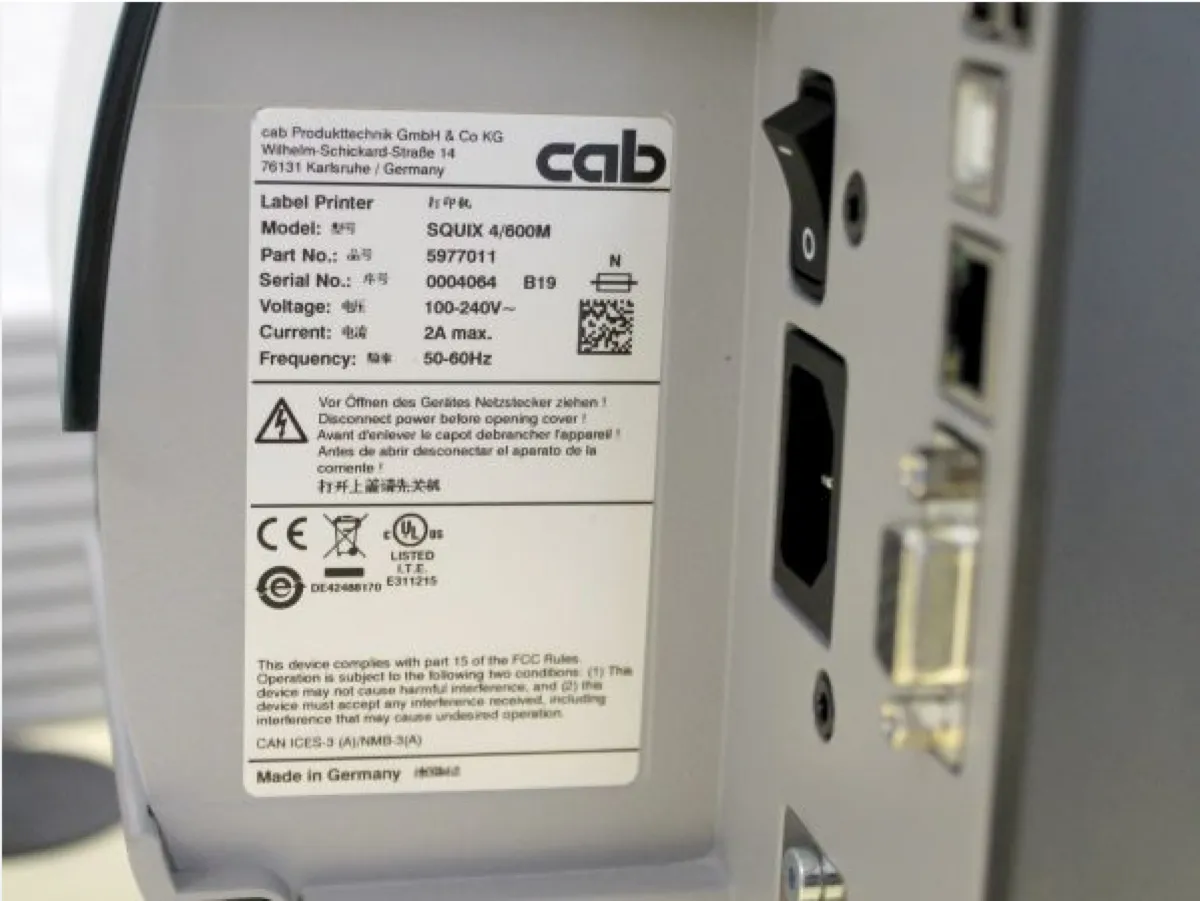 Plaque constructeur gravée laser apposée sur machine industrielle, numéro de série et données techniques lisibles